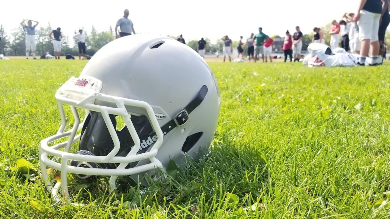 Un casque de football posé à terre.