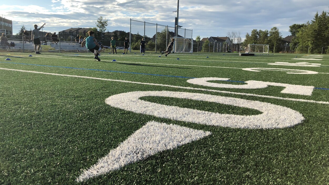 Un terrain de football avec des joueurs qui s'entraînent.