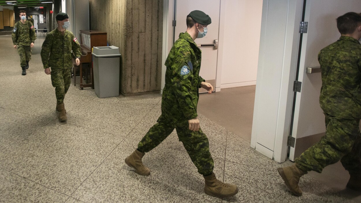 Des militaires portant un masque respectent une bonne distance entre eux.