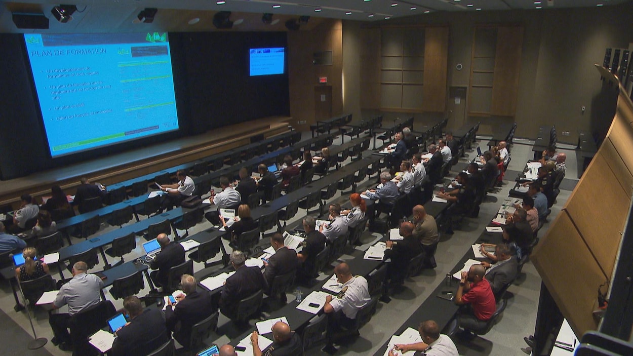 Près de 100 personnes assises dans une salle de l'École nationale de police du Québec pour suivre une formation.