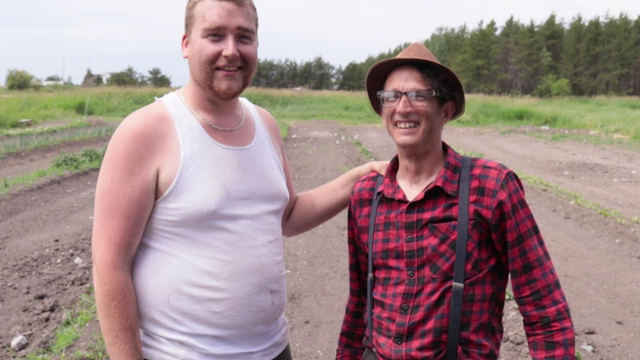 Ti-Louis, joué par Kevin Bisonnette, et Passe-Poil, l'agronome, joué par Stéphane Bisson, posent dans un champ.