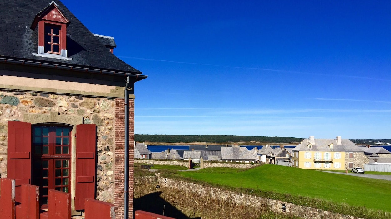 Des maisons en pierres d'allure ancienne avec la mer en arrière-plan