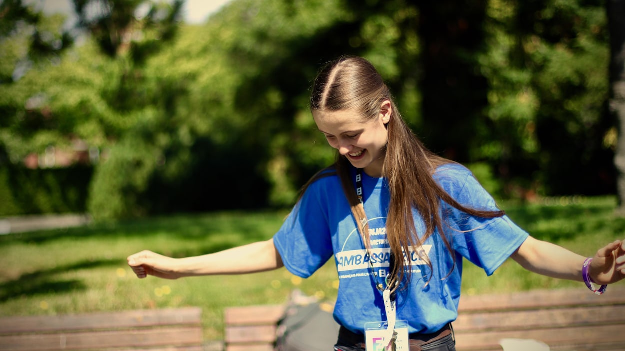 Une adolescente danse dans un parc.