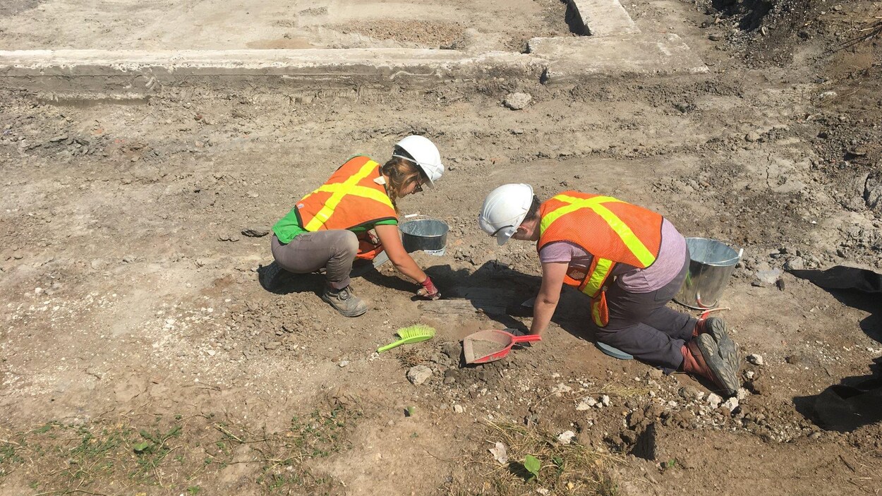 Deux personnes mènent des fouillent archéologique sur le terrain du futur pôle d'échange de transport en commun Saint-Roch à Québec