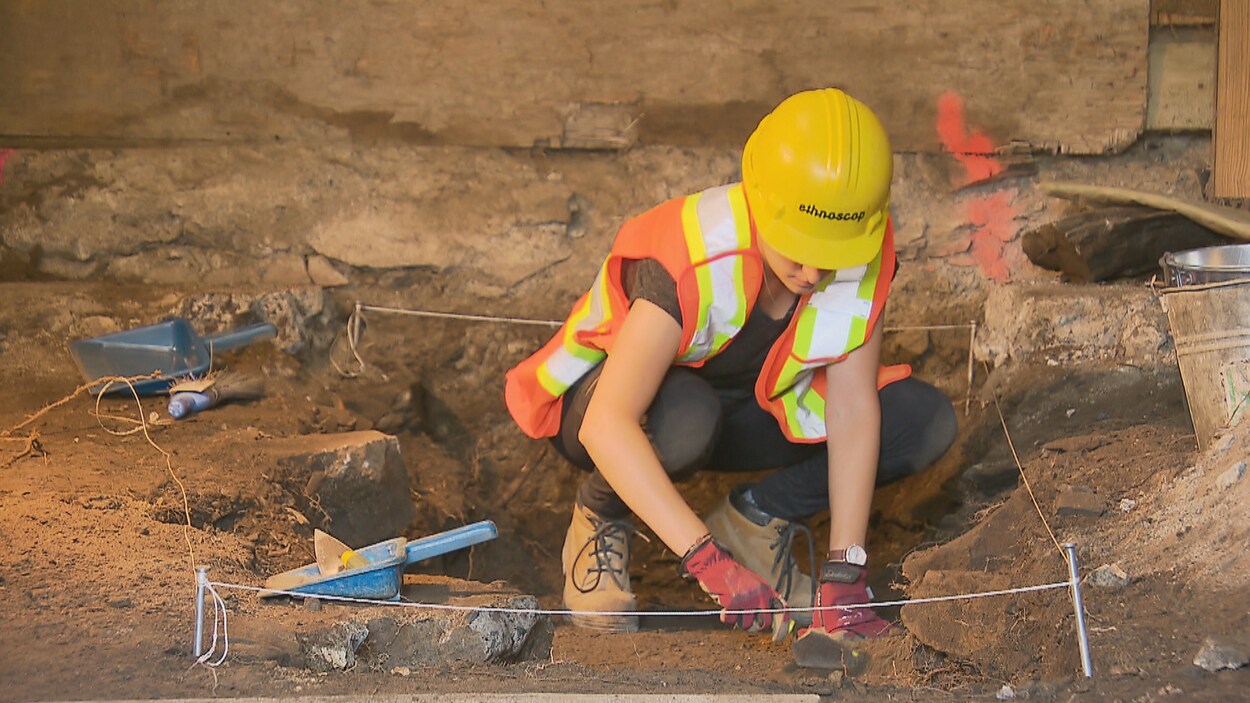 Une archéologue qui déterre tranquillement les vestiges d'une fondation.