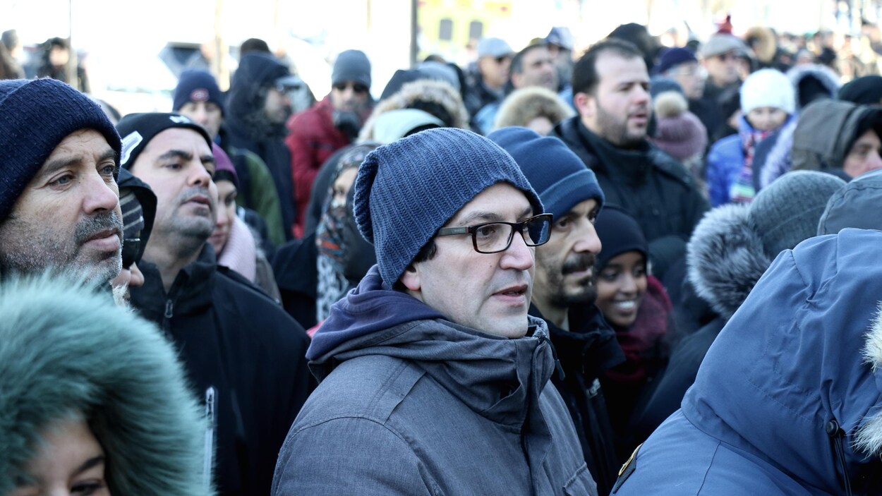 Des personnes attendent avant d'entrer dans l'aréna Maurice-Richard pour les funérailles des victimes de la tuerie de Québec.