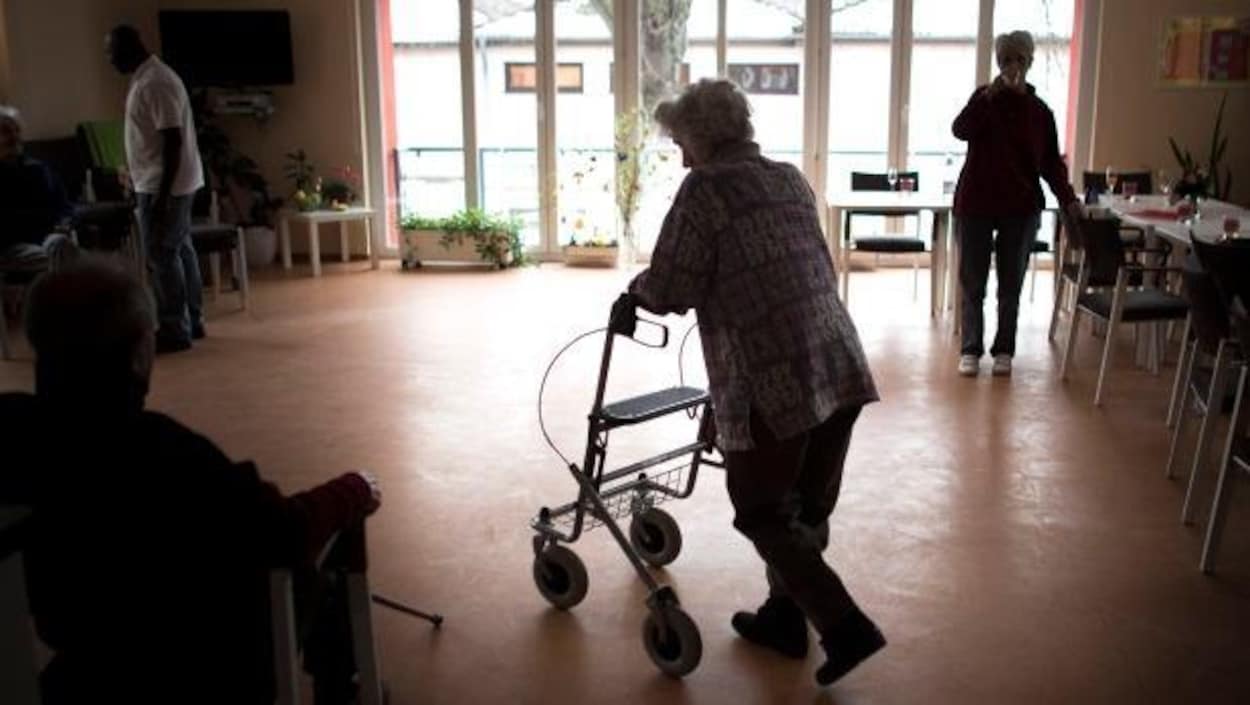 Les silhouettes de deux personnes âgées qui marchent dans un salon