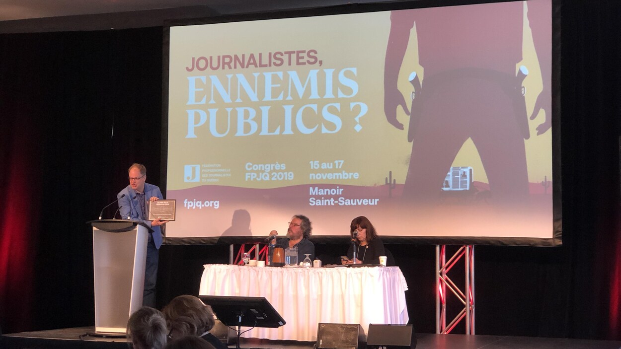 Stéphane Giroux, sur une scène, présente une plaque pour le prix remis au MAPAQ.