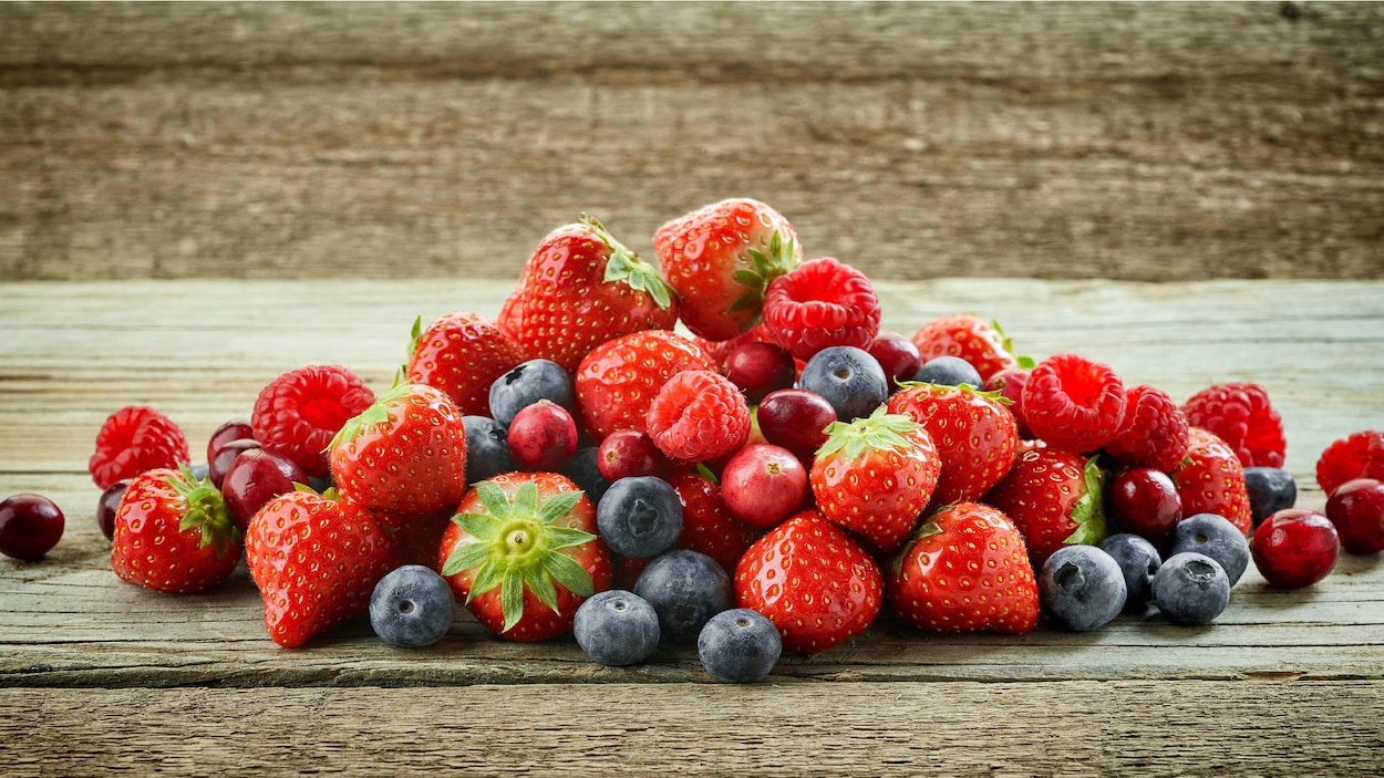 Des petits fruits reposent sur une table.