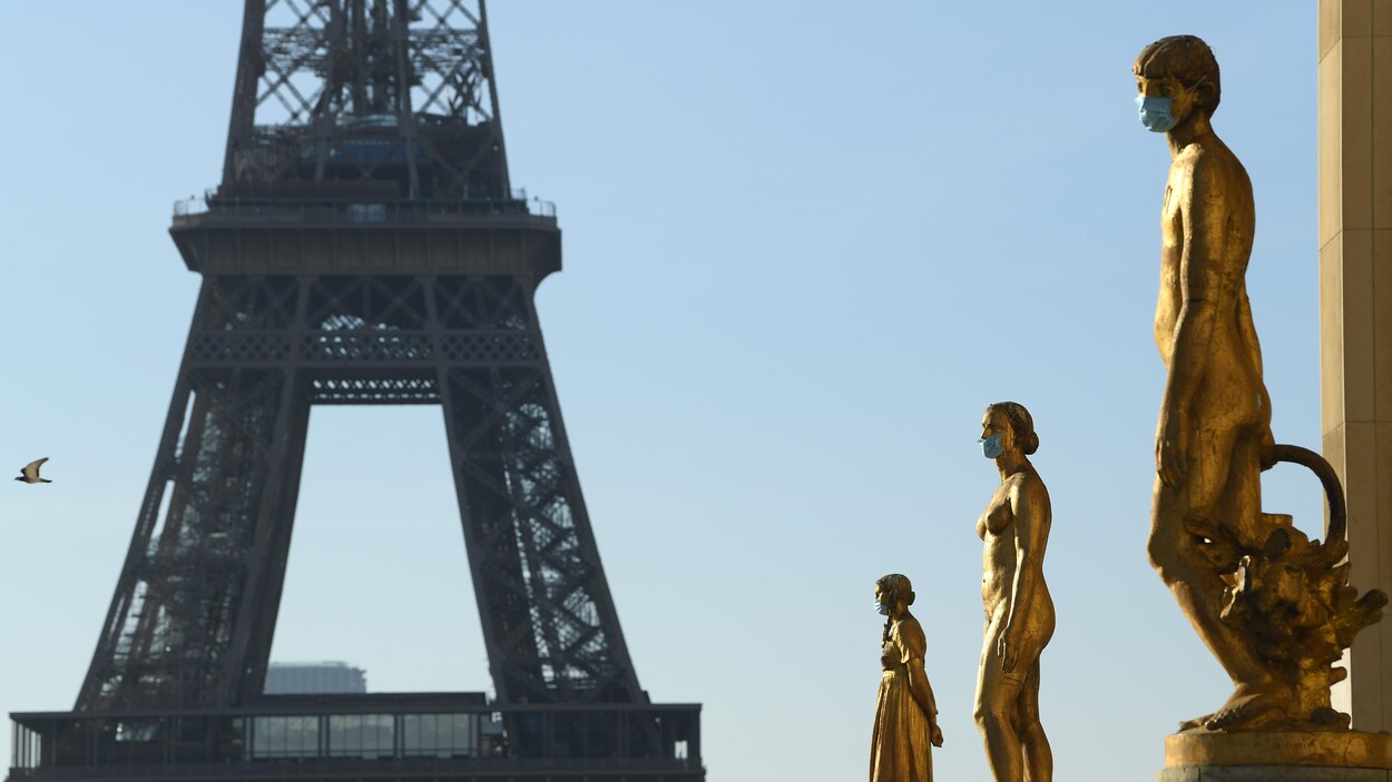 Des statues à la place du Trocadéro à Paris portent des masques médicaux.