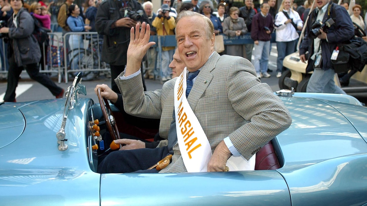 Franco Zeffirelli, dans une voiture décapotable, salue la foule et les journalistes sur une rue de New York.