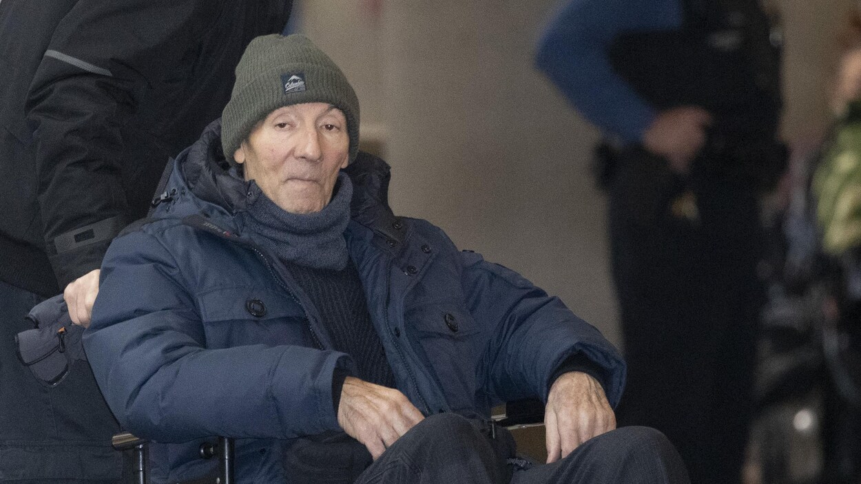 Un homme en fauteuil roulant avec une tuque et un manteau