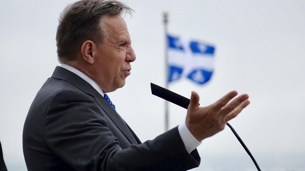 François Legault, de profil, s'adresse à un auditoire.