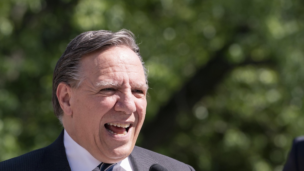 Portrait de François Legault en conférence de presse à l'extérieur.