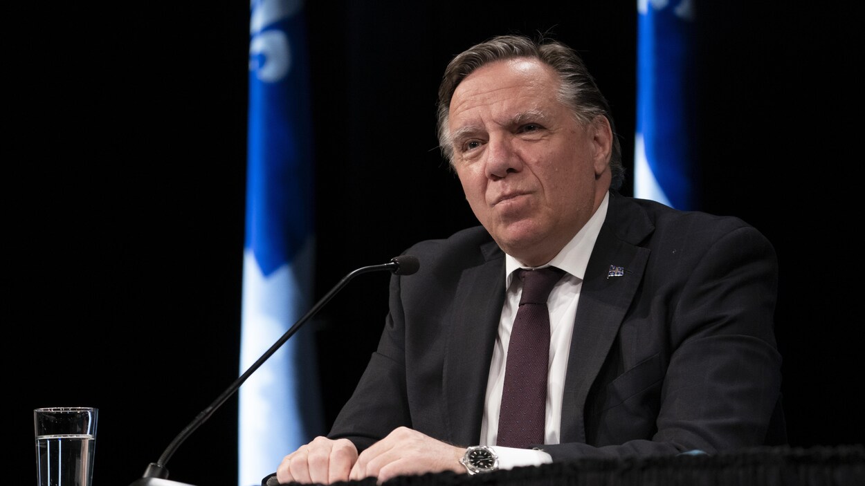 Le premier ministre du Québec, François Legault, assis durant une conférence de presse.