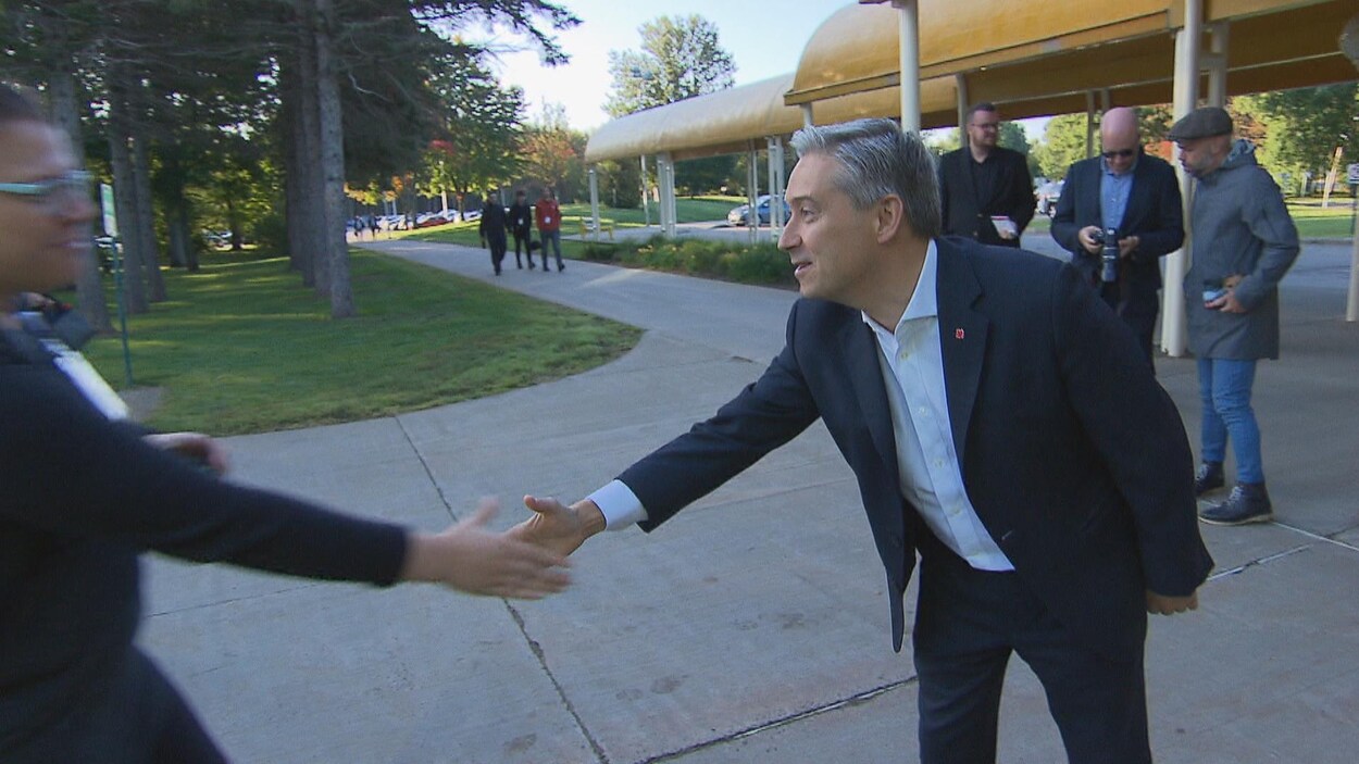 François-Philippe Champagne qui s'étire le bras pour serrer la main d'une électrice.