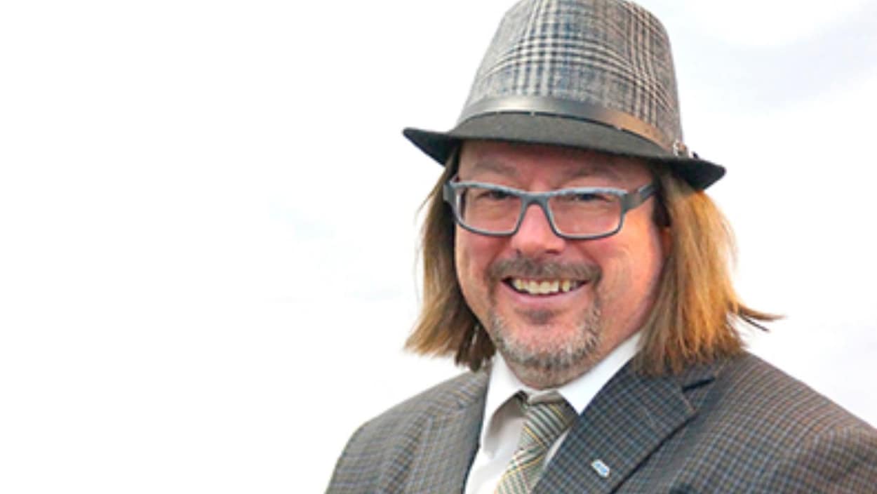 Photo professionnelle de François Rouleau, un homme avec un complet et un chapeau.