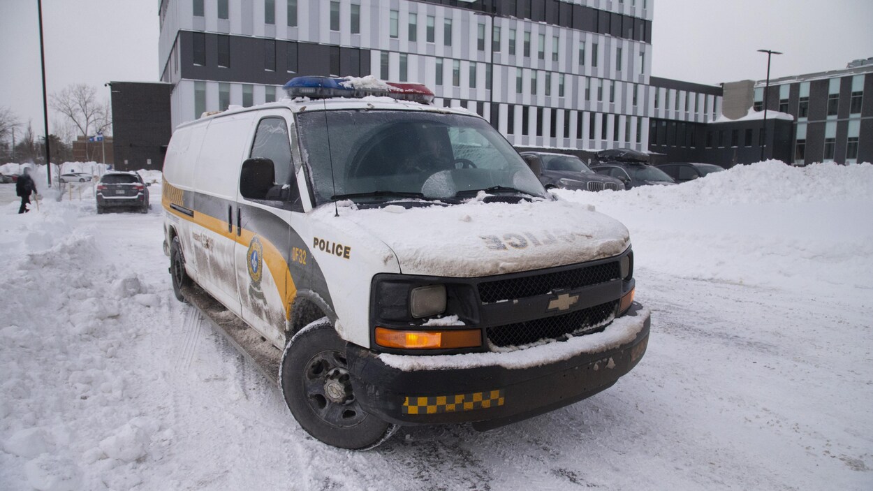 Une fourgonnette de la Sûreté du Québec dans un stationnement enneigé.