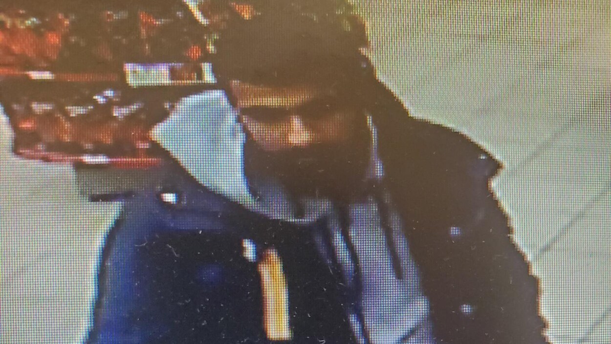 Le suspect procède à un paiement à la casse d'un commerce.