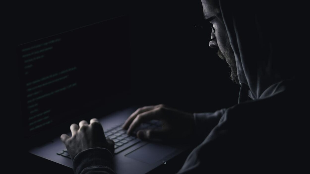 Une personne écrit sur le clavier d'un ordinateur portable