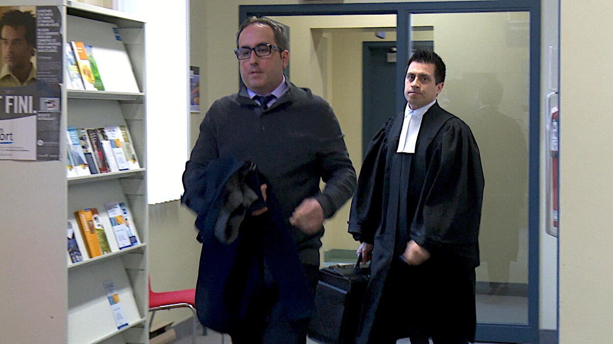 Homme qui marche avec un avocat derrière lui.