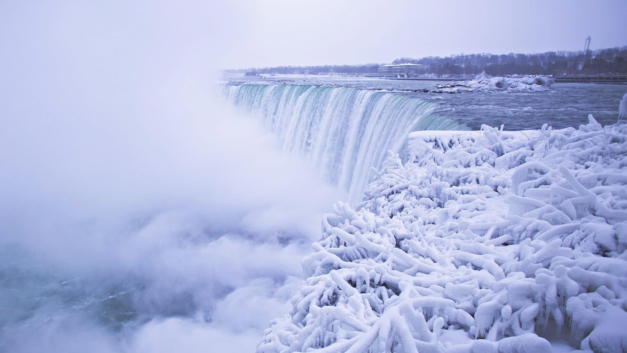 Un épais brouillard monte des chutes Niagara, alors que les berges sont couvertes de glace et de neige. Un épais brouillard monte des chutes Niagara, alors que les berges sont couvertes de glace et de neige.