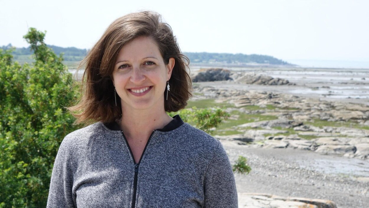 Karine Vincent sourit devant le fleuve Saint-Laurent.