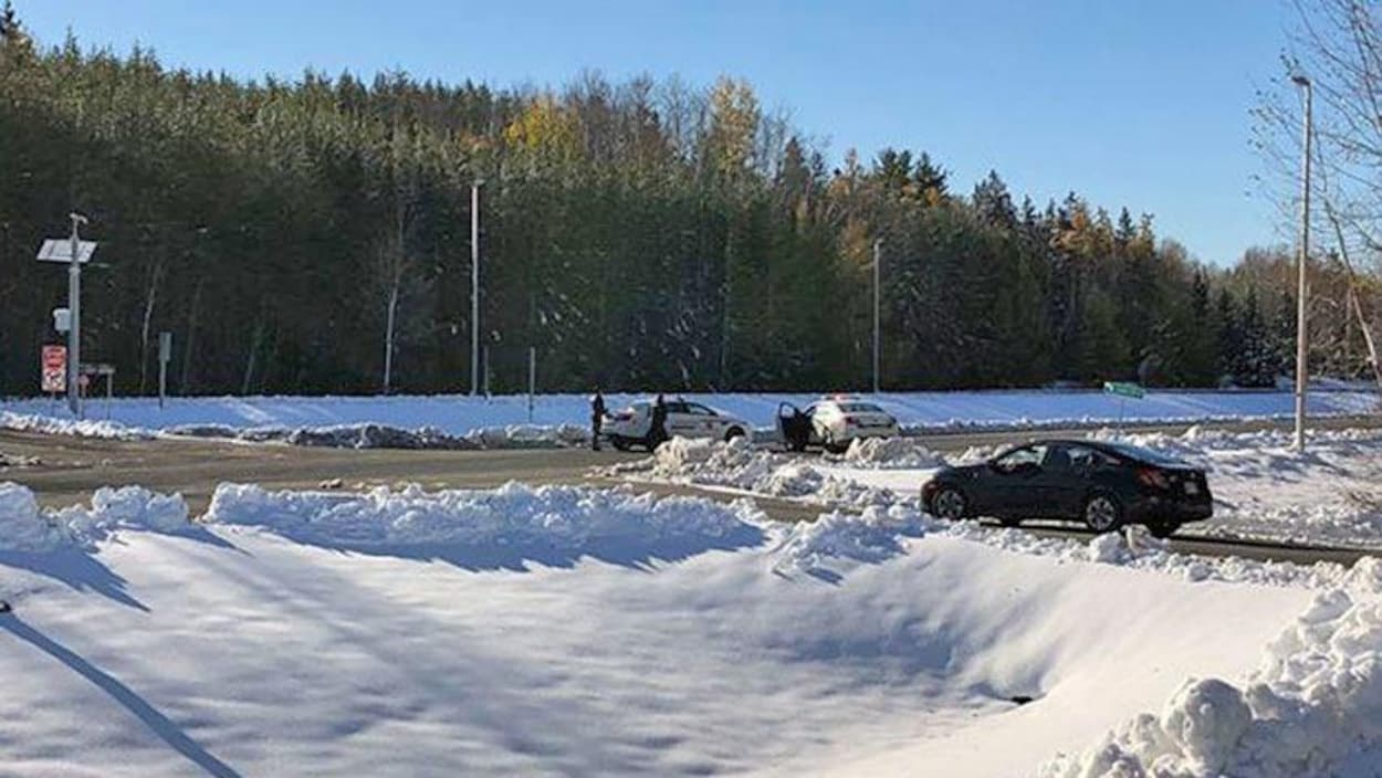 Des voitures de police sur une voie d'accès à la frontière