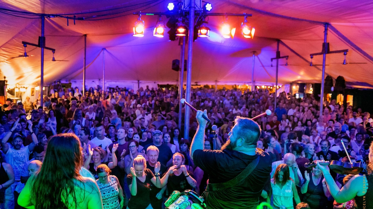 Un chapiteau plein lors du 22e Festival des traditions du monde de Sherbrooke alors qu'un groupe joue sur la scène.