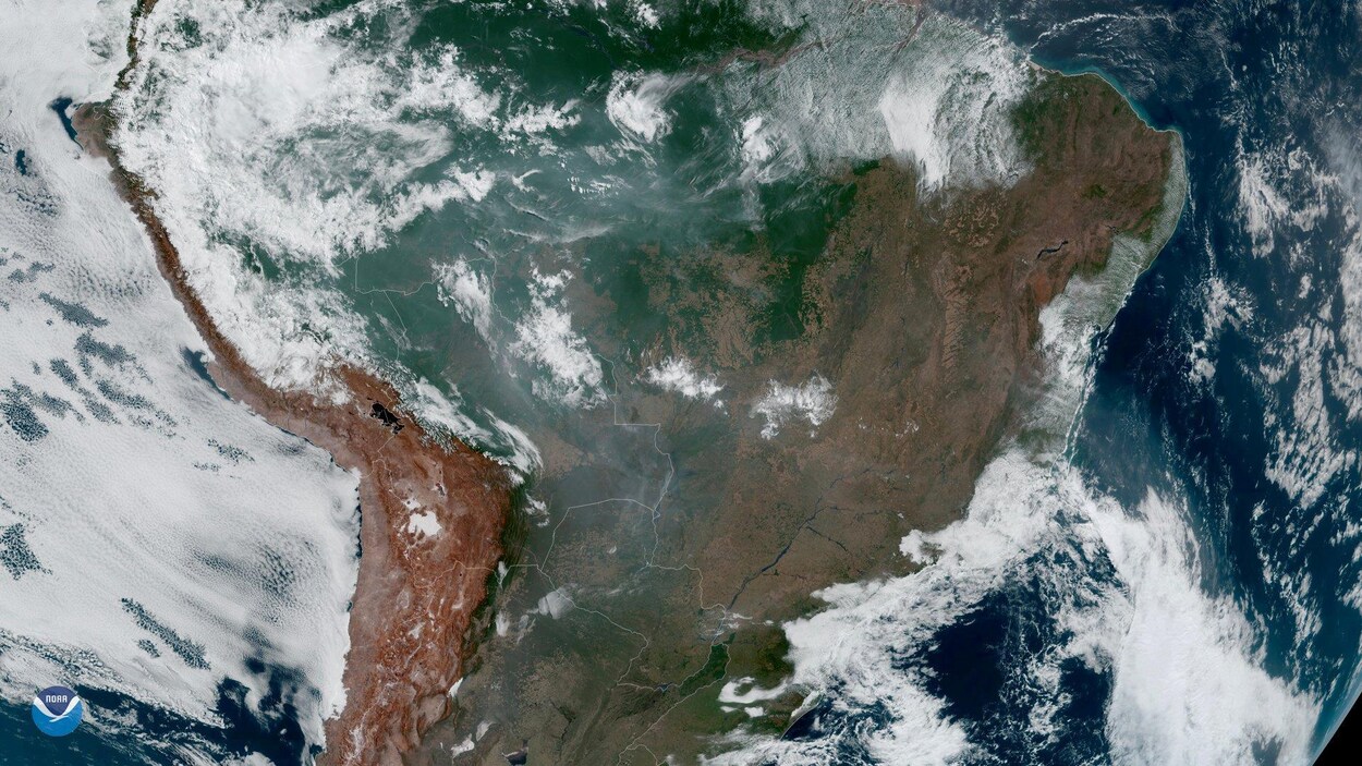 Une vaste portion de l'Amérique du Sud, partiellement recouverte de nuages et de fumée.