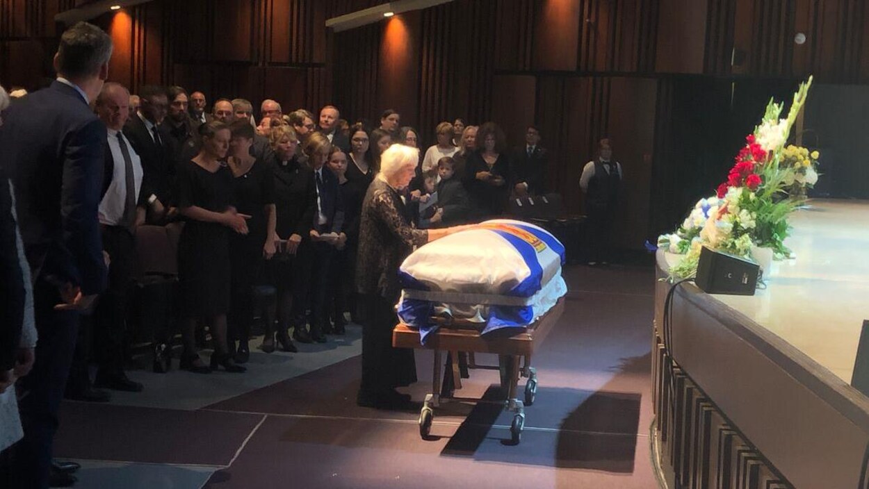 Mavis Buchanan est devant le cercueil couvert du drapeau de la Nouvelle-Écosse.