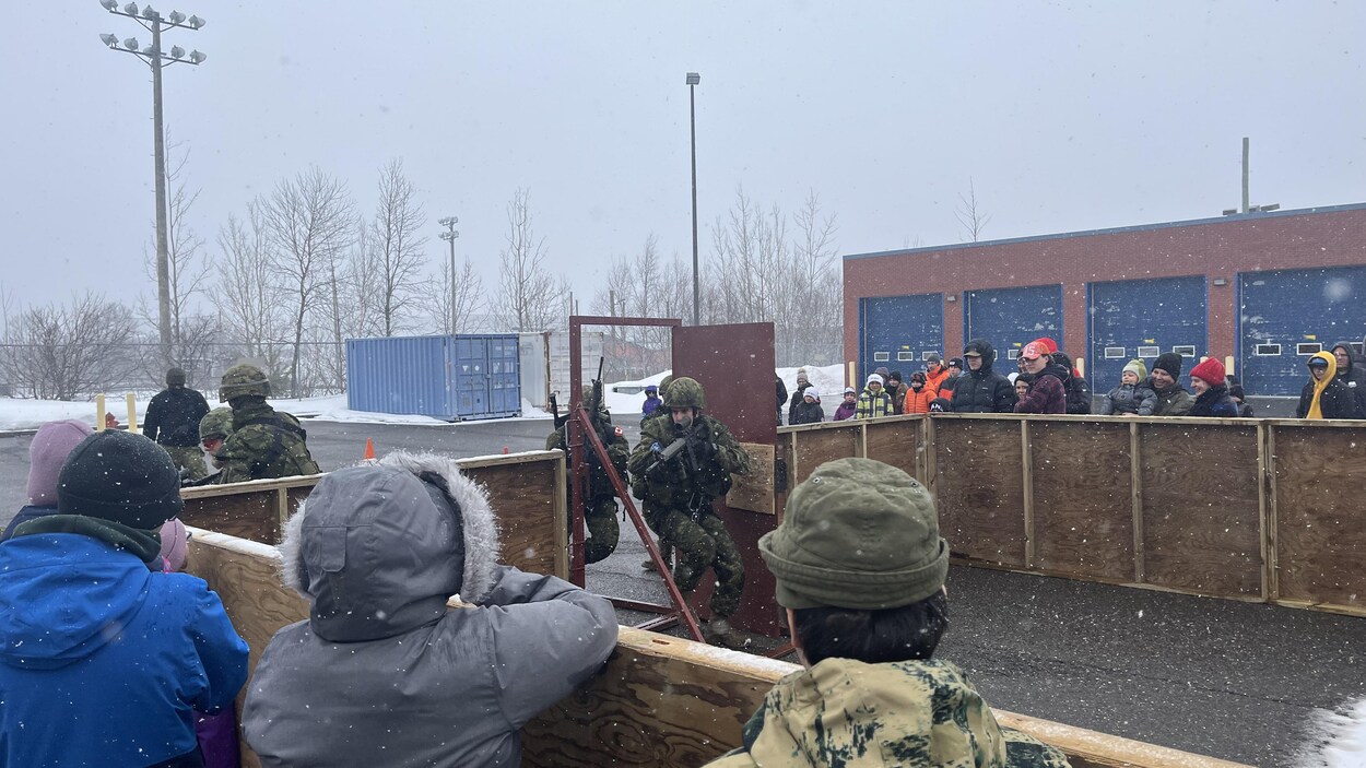 Des hommes des forces armées canadiennes font une simulation d'une entrée dans un bâtiment.