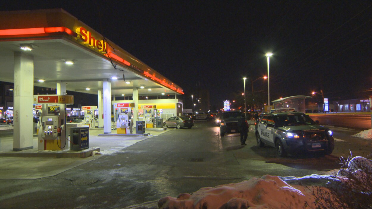 Des policiers dans une station service la nuit.