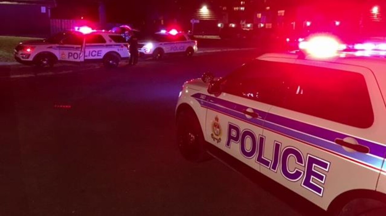 Trois voitures de police devant un immeuble à logement. Trois voitures de police devant un immeuble à logement.
