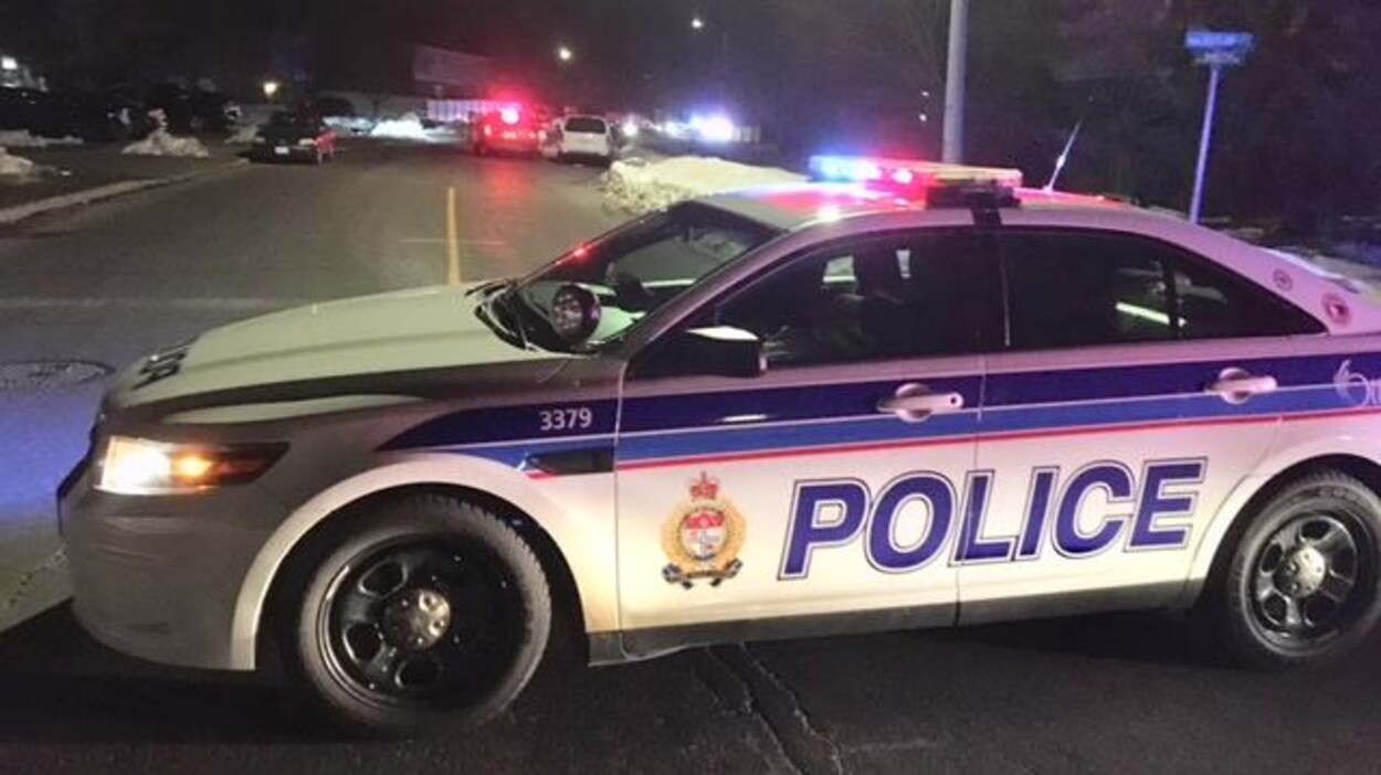 Une voiture de police bloque une rue. Ses gyrophares sont allumés. Une voiture de police bloque une rue. Ses gyrophares sont allumés.