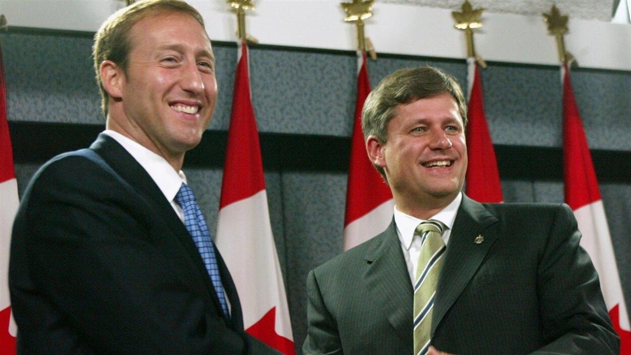 Peter MacKay et Stephen Harper, tout sourire, se serrent la main après une conférence de presse à Ottawa.