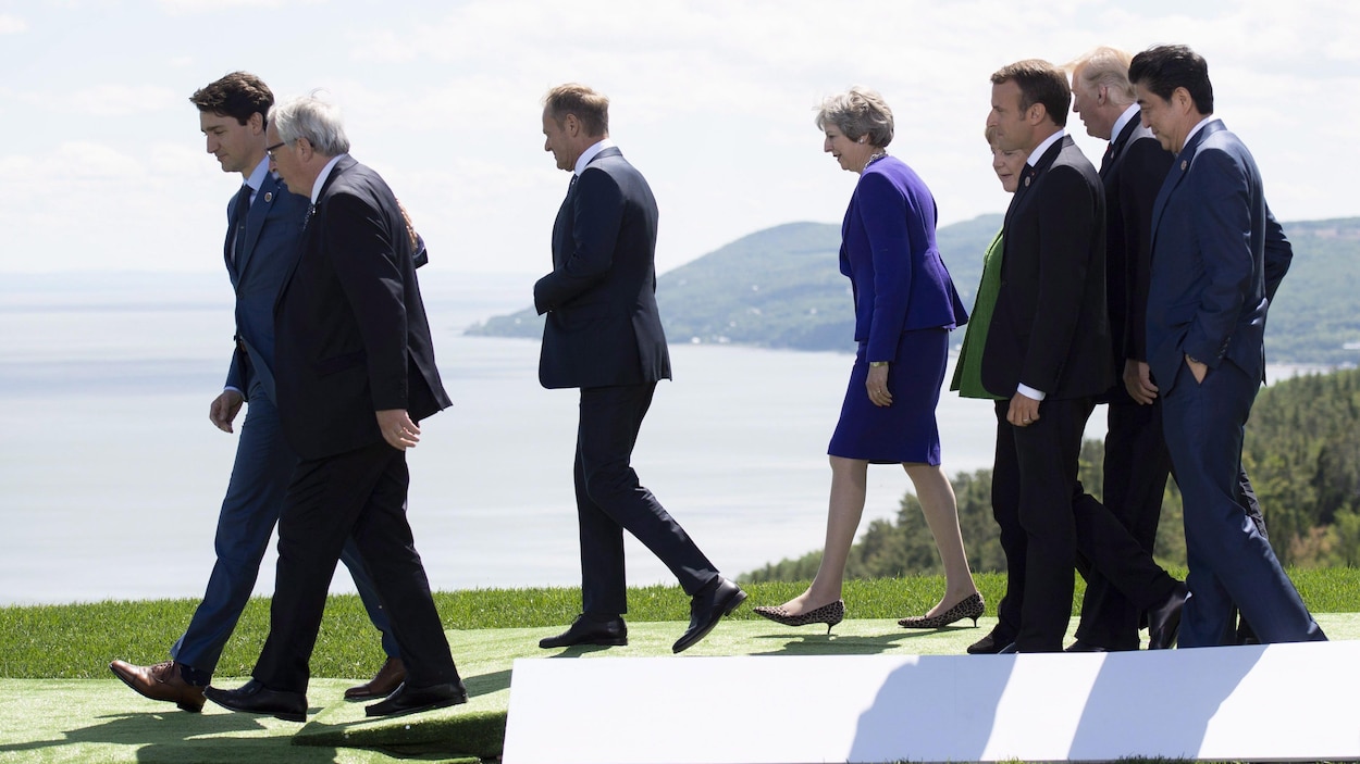 Les dirigeants marchent à l'extérieur, devant le fleuve Saint-Laurent.