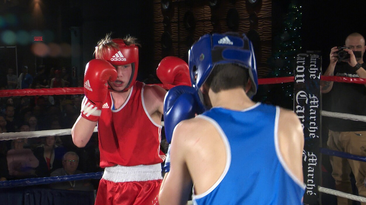 Deux jeunes boxeurs s'affrontent dans l'arène.