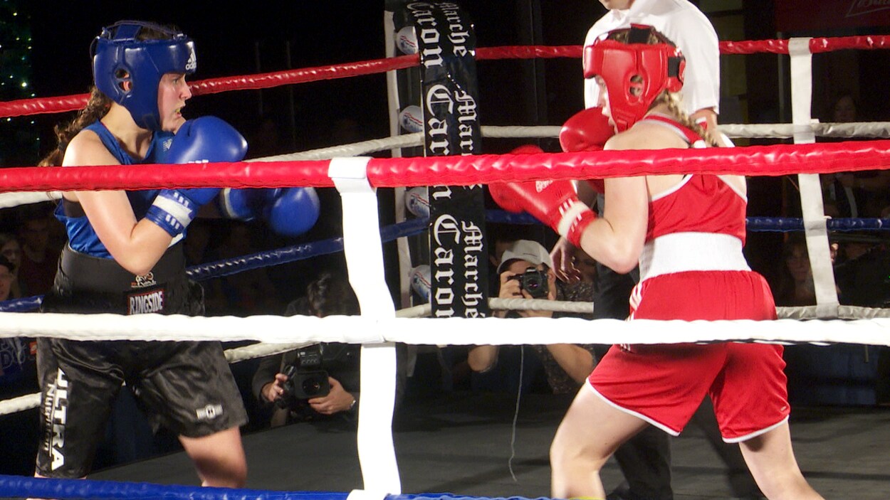 Deux boxeuses s'affrontent dans l'arène.