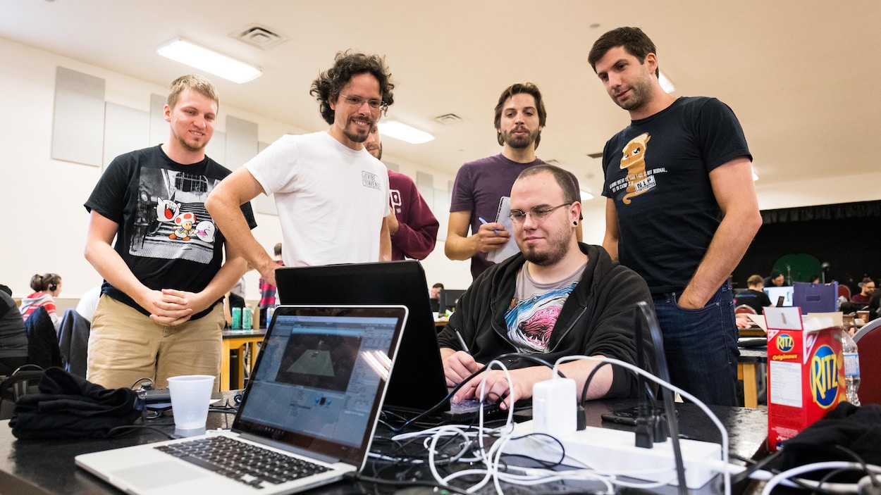 Six jeunes hommes réunis autour d'un ordinateur portable. Six jeunes hommes réunis autour d'un ordinateur portable.
