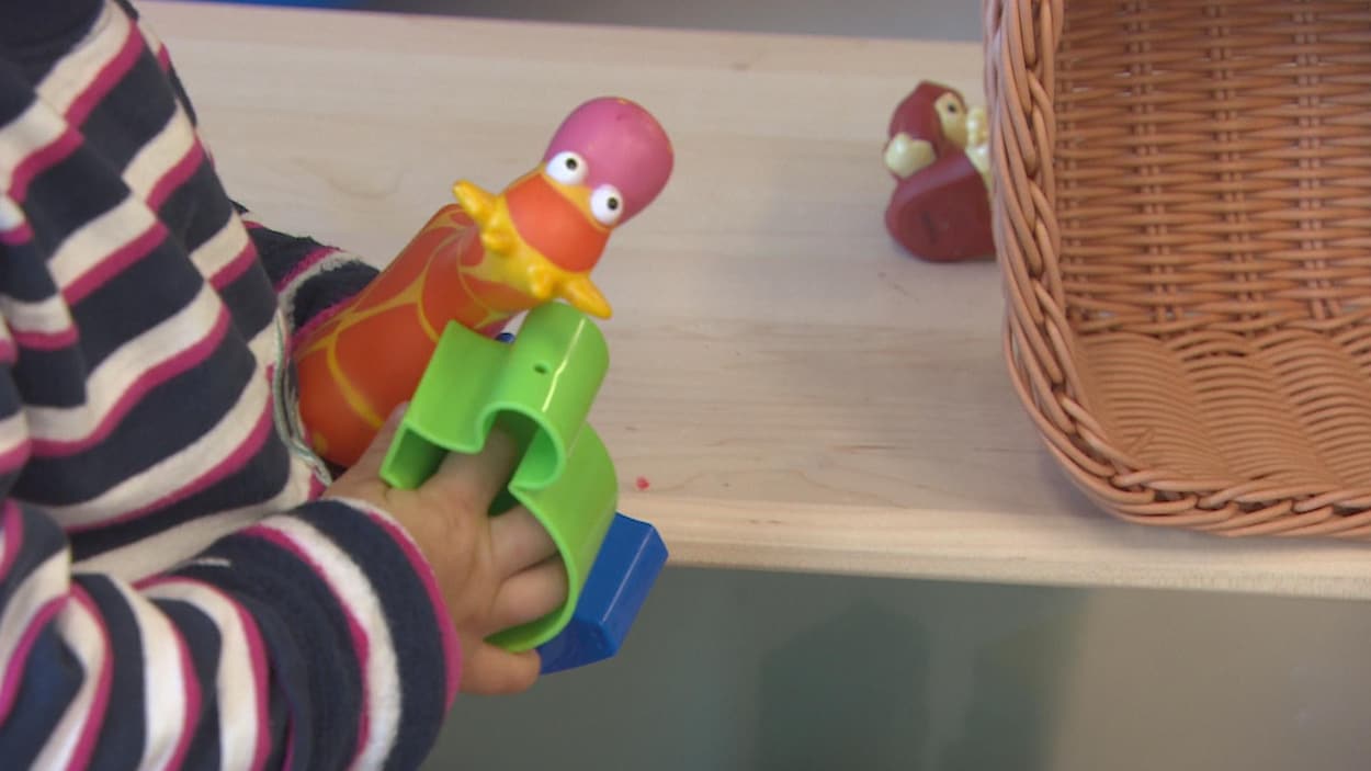 Un enfant dont on ne voit que les mains tient de jouets. Un enfant dont on ne voit que les mains tient de jouets.