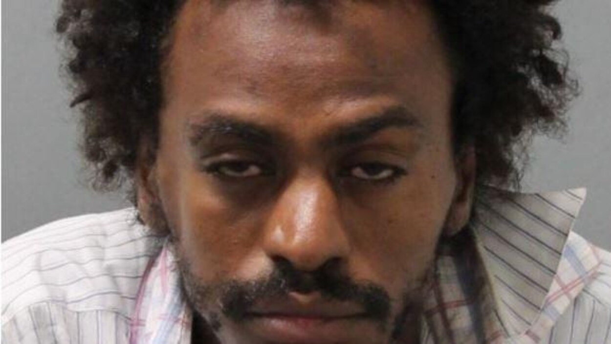 Portrait d'un homme noir aux cheveux bouclés avec le regard absent.