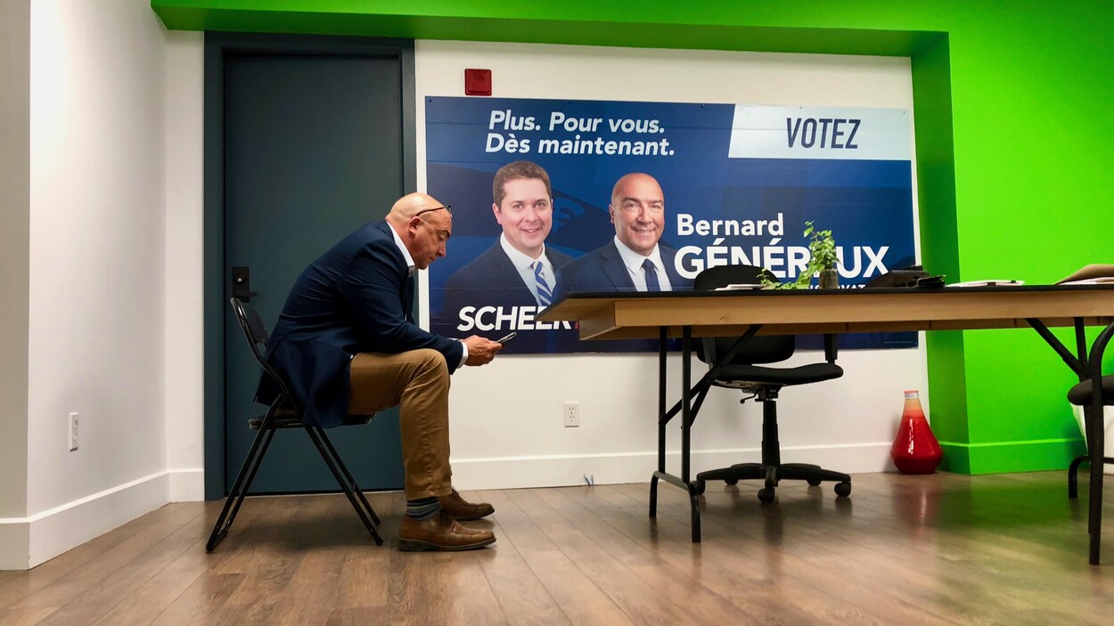 Le député sortant et candidat conservateur Bernard Généraux regarde ses messages sur son téléphone mobile dans son bureau de campagne de Rivière-du-Loup.