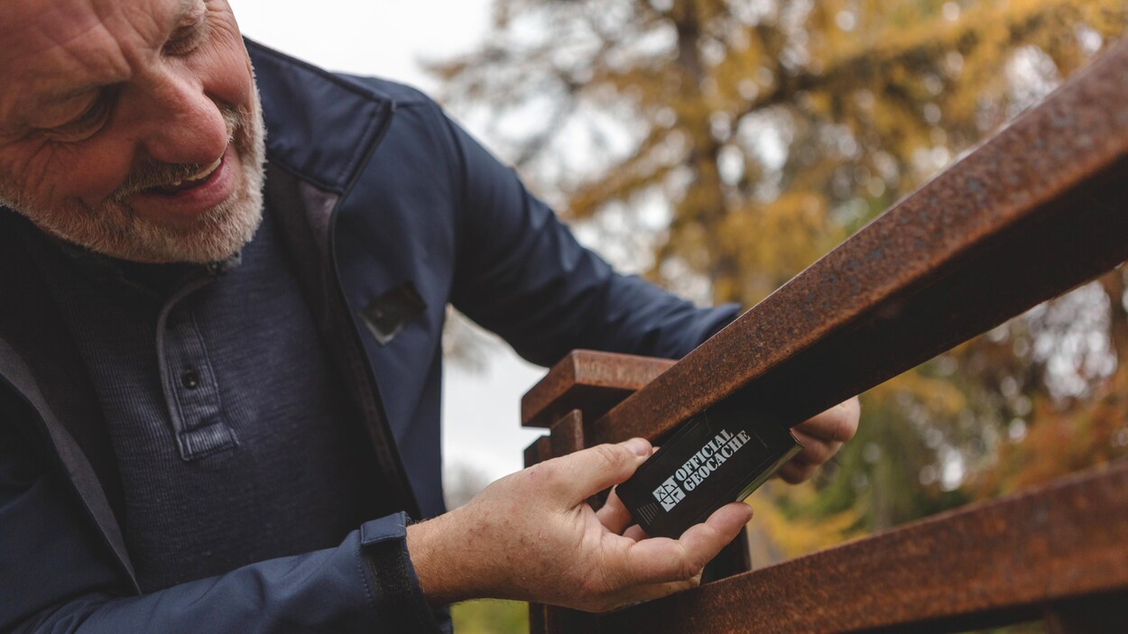 Un homme trouve une géocache.