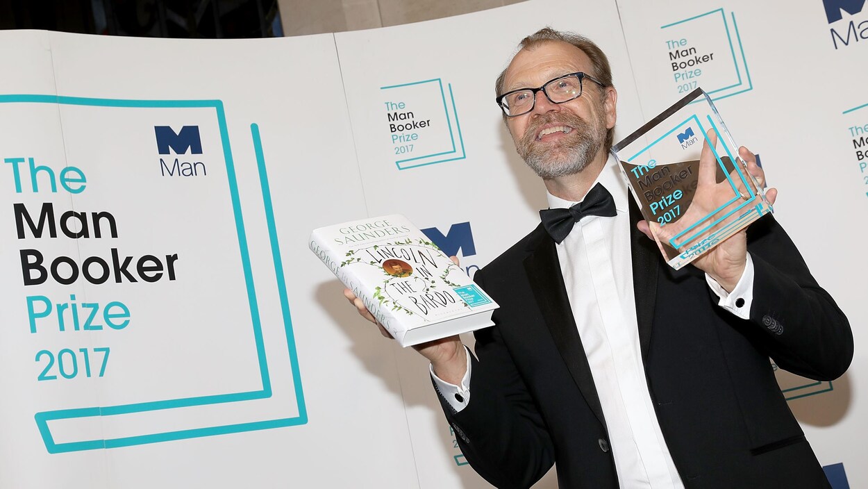 Le gagnant du Man Booker Prize, George Saunders, montre le trophée et son roman. Le gagnant du Man Booker Prize, George Saunders, montre le trophée et son roman.