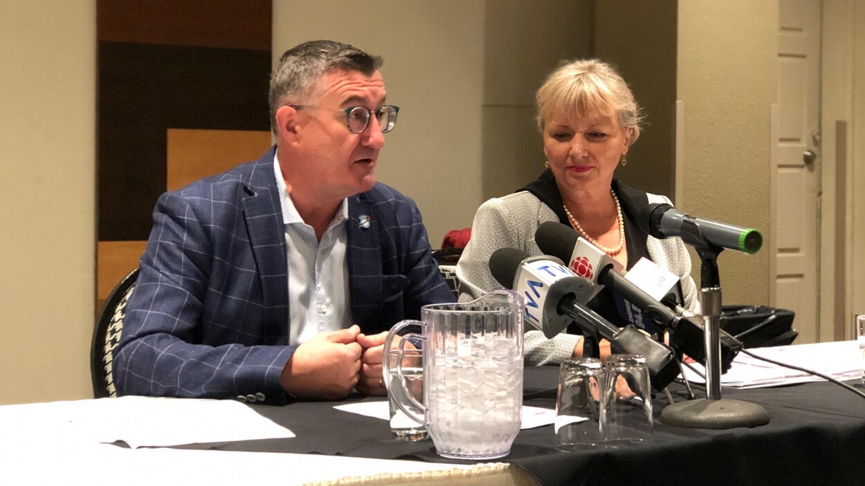 Étienne Jacques et Joan Simard assis à une table derrière des micros.
