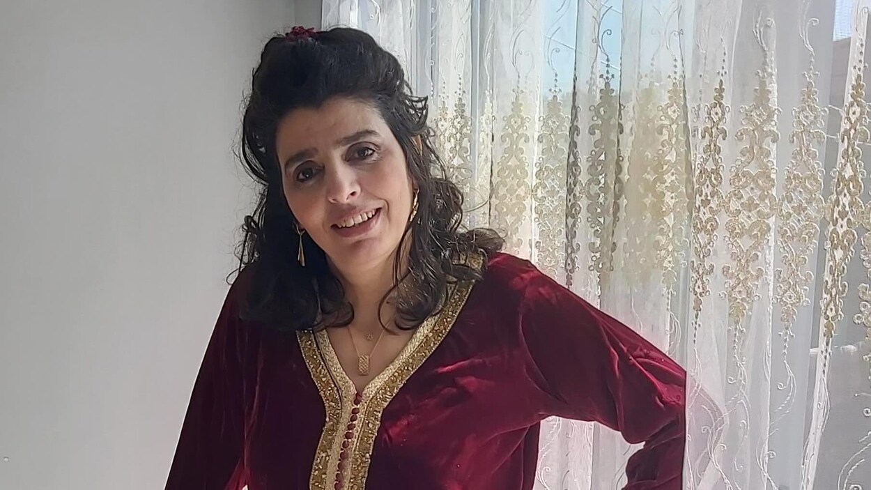 Elle sourit à la caméra.