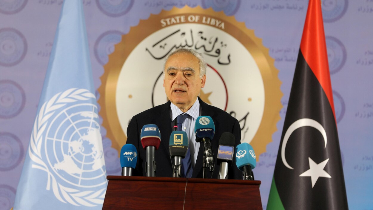 L'émissaire de l'ONU en Libye, Ghassan Salamé, debout devant un pupitre avec les drapeaux de la Libye et de l'ONU derrière lui.