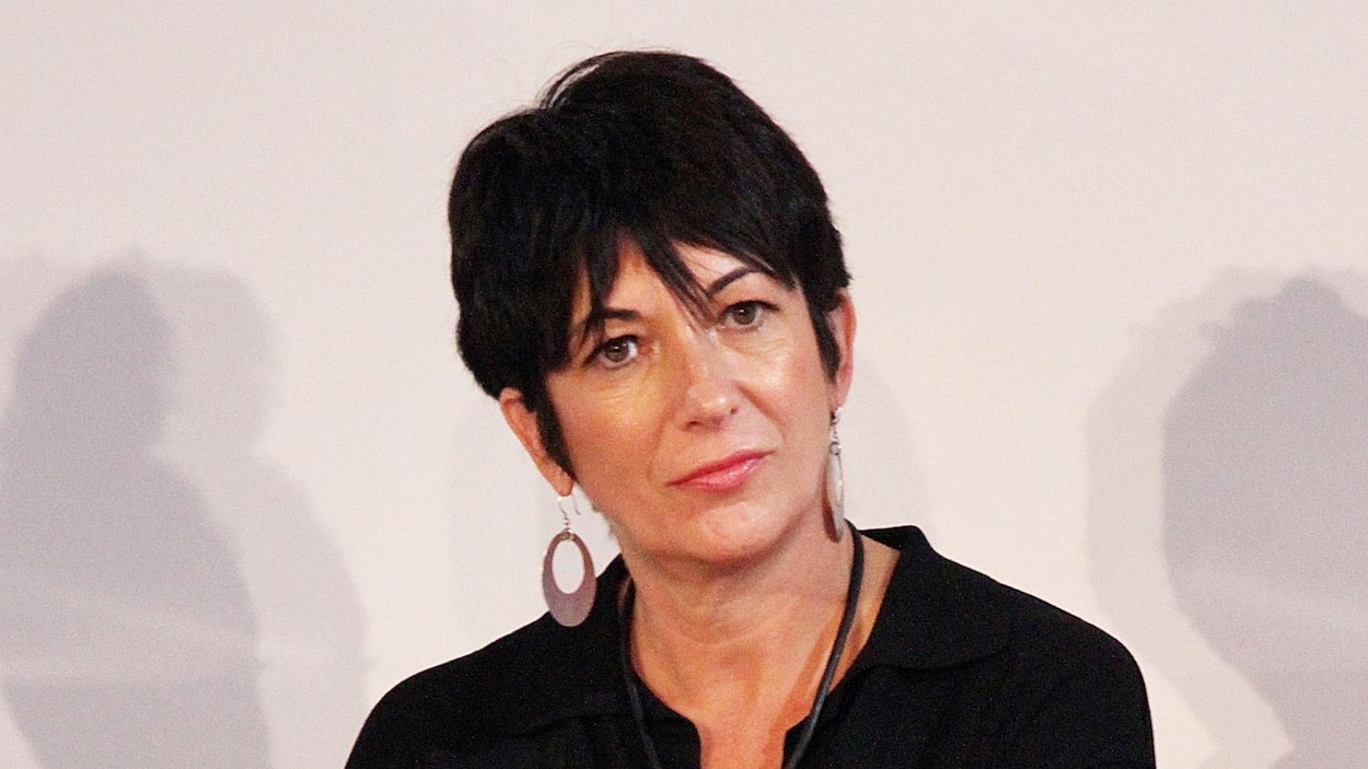 Ghislaine Maxwell est assise, micro à la main, lors d'un événement mondain.