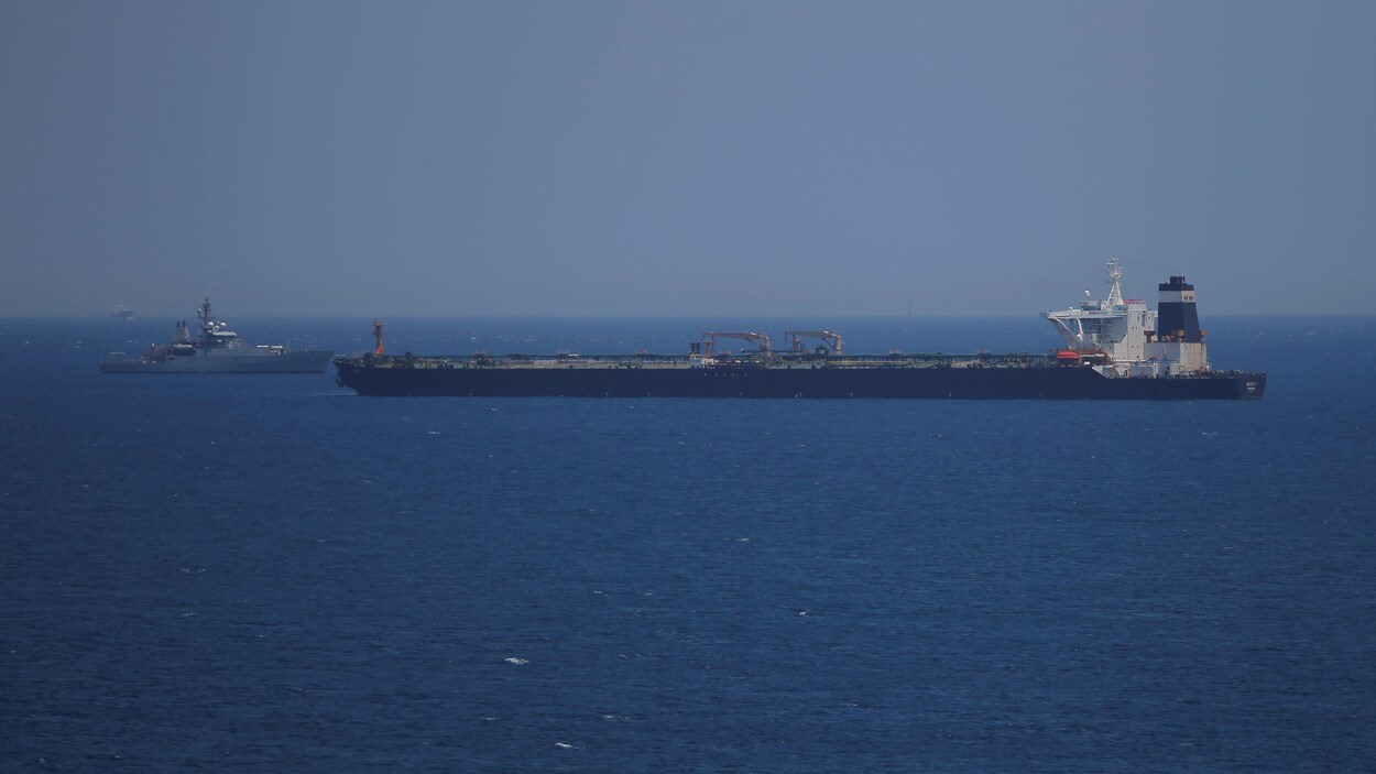 Un pétrolier et une frégate se font face au large d'une mer.